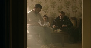 Movie still from “The Snowtown Murders” (2011), directed by Justin Kurzel – Three people sitting on a couch in a living room; Wide shot, High angle
