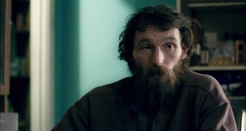 Movie still from “The Snowtown Murders” (2011), directed by Justin Kurzel – A man with a long beard is sitting in a room; Close Up shot, Over the shoulder angle