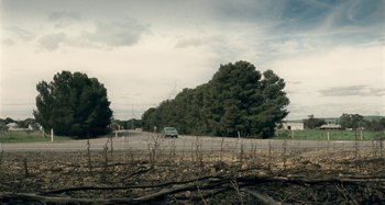 Movie still from “The Snowtown Murders” (2011), directed by Justin Kurzel – A car driving down a road next to trees; Extreme Wide shot, High angle