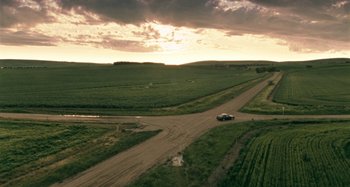 Movie still from “The Snowtown Murders” (2011), directed by Justin Kurzel – A car driving down a dirt road near a field; Extreme Wide shot, High angle