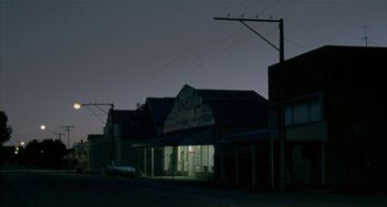 Movie still from “The Snowtown Murders” (2011), directed by Justin Kurzel – An empty street at night with a car parked on the side of the road; Extreme Wide shot, Low angle