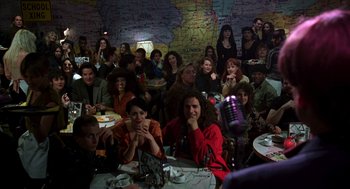 Movie still from “So I Married an Axe Murderer” (1993), directed by Thomas Schlamme – A group of people sitting at a table with microphones; Wide shot, High angle
