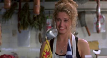 Movie still from “So I Married an Axe Murderer” (1993), directed by Thomas Schlamme – A woman in a white apron holding a flag in a kitchen; Close Up shot, Over the shoulder angle