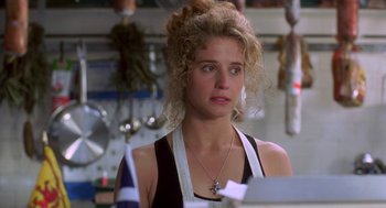 Movie still from “So I Married an Axe Murderer” (1993), directed by Thomas Schlamme – A woman in a kitchen wearing an apron and looking at the camera; Close Up shot, Over the shoulder angle