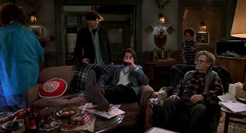 Movie still from “So I Married an Axe Murderer” (1993), directed by Thomas Schlamme – A group of people sitting on a couch in a living room; Wide shot, High angle