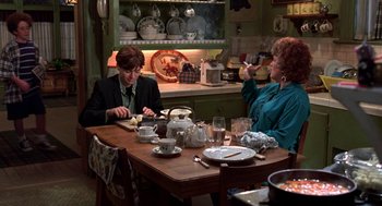 Movie still from “So I Married an Axe Murderer” (1993), directed by Thomas Schlamme – Two people sitting at a table in a kitchen; Medium shot, High angle