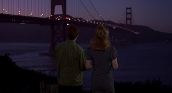 Movie still from “So I Married an Axe Murderer” (1993), directed by Thomas Schlamme – Two people looking out at the golden gate bridge at night; Wide shot, Over the shoulder angle
