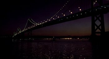Movie still from “So I Married an Axe Murderer” (1993), directed by Thomas Schlamme – A view of a bridge lit up at night; Extreme Wide shot, Low angle