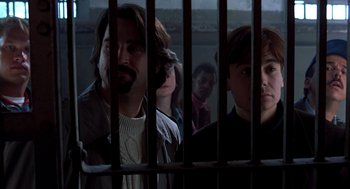 Movie still from “So I Married an Axe Murderer” (1993), directed by Thomas Schlamme – A group of people behind bars in a jail cell; Close Up shot, Low angle