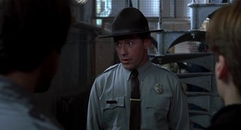 Movie still from “So I Married an Axe Murderer” (1993), directed by Thomas Schlamme – A man wearing a hat and a uniform; Close Up shot, Over the shoulder angle