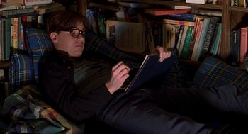 Movie still from “So I Married an Axe Murderer” (1993), directed by Thomas Schlamme – A man is laying on the floor reading a book; Medium shot, High angle