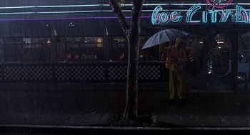 Movie still from “So I Married an Axe Murderer” (1993), directed by Thomas Schlamme – A person with an umbrella standing in the rain; Extreme Wide shot, High angle