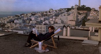 Movie still from “So I Married an Axe Murderer” (1993), directed by Thomas Schlamme – A man sitting in a chair on top of a building; Wide shot, High angle