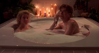 Movie still from “So I Married an Axe Murderer” (1993), directed by Thomas Schlamme – A man and woman in a bath tub with candles in the background; Medium shot, High angle