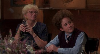 Movie still from “So I Married an Axe Murderer” (1993), directed by Thomas Schlamme – Two people sitting at a table with a glass of wine; Medium shot, Over the shoulder angle