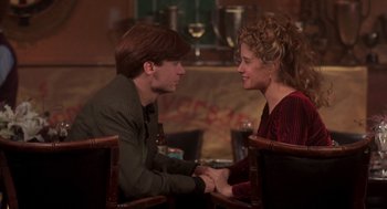 Movie still from “So I Married an Axe Murderer” (1993), directed by Thomas Schlamme – A man and a woman sitting at a table holding hands; Medium shot, Over the shoulder angle