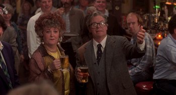 Movie still from “So I Married an Axe Murderer” (1993), directed by Thomas Schlamme – A man and a woman standing next to each other holding beers; Medium shot, Low angle