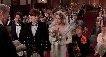 Movie still from “So I Married an Axe Murderer” (1993), directed by Thomas Schlamme – A man and a woman are standing in front of a crowd; Medium shot, Over the shoulder angle