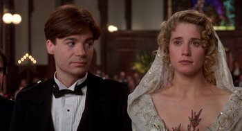 Movie still from “So I Married an Axe Murderer” (1993), directed by Thomas Schlamme – A man and a woman standing next to each other in front of an audience; Close Up shot, Over the shoulder angle