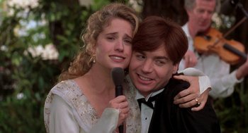 Movie still from “So I Married an Axe Murderer” (1993), directed by Thomas Schlamme – A man and a woman are holding a microphone; Close Up shot, Over the shoulder angle