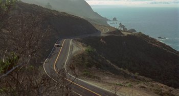 Movie still from “So I Married an Axe Murderer” (1993), directed by Thomas Schlamme – An aerial view of a road on the side of a mountain; Extreme Wide shot, High angle