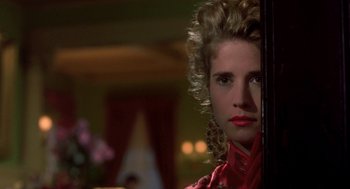 Movie still from “So I Married an Axe Murderer” (1993), directed by Thomas Schlamme – A woman in a red dress is looking at the camera; Close Up shot, Over the shoulder angle