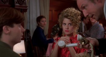 Movie still from “So I Married an Axe Murderer” (1993), directed by Thomas Schlamme – A young woman in a red dress dries her hair with a blow dryer; Close Up shot, Over the shoulder angle
