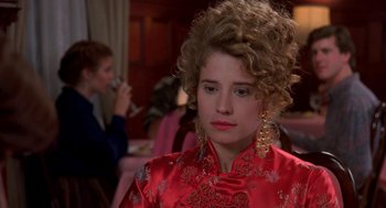 Movie still from “So I Married an Axe Murderer” (1993), directed by Thomas Schlamme – A woman in a red dress is sitting in front of other people; Close Up shot, Over the shoulder angle