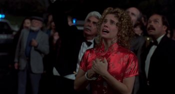 Movie still from “So I Married an Axe Murderer” (1993), directed by Thomas Schlamme – A woman in a red dress is praying; Medium shot, Low angle