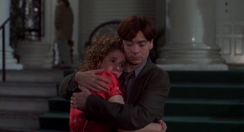 Movie still from “So I Married an Axe Murderer” (1993), directed by Thomas Schlamme – A man and a woman hugging each other in front of a building; Medium shot, High angle