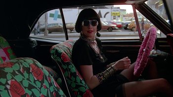 Movie still from “Something Wild” (1986), directed by Jonathan Demme – A woman sitting in the back seat of a car; Medium shot, Over the shoulder angle