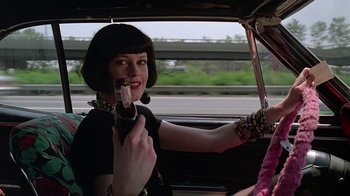 Movie still from “Something Wild” (1986), directed by Jonathan Demme – A woman in black shirt holding a camera in a car; Close Up shot, Over the shoulder angle