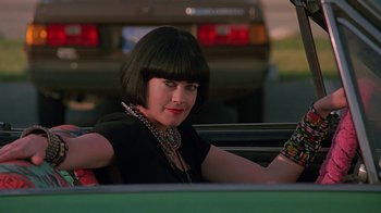 Movie still from “Something Wild” (1986), directed by Jonathan Demme – A woman sitting in the back seat of a car; Close Up shot, Low angle