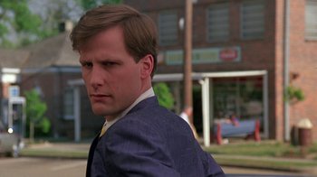 Movie still from “Something Wild” (1986), directed by Jonathan Demme – A man wearing a suit and tie standing on the side of the road; Close Up shot, Low angle