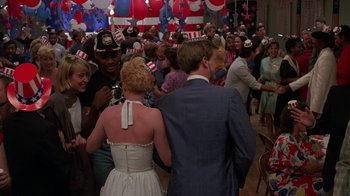 Movie still from “Something Wild” (1986), directed by Jonathan Demme – A group of people standing in a room with hats on their heads; Wide shot, High angle