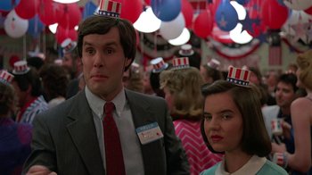 Movie still from “Something Wild” (1986), directed by Jonathan Demme – A man and a woman wearing party hats in front of balloons; Close Up shot, Low angle