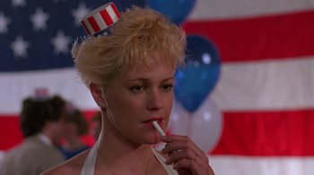 Movie still from “Something Wild” (1986), directed by Jonathan Demme – A woman wearing a hat with a flag on top of her head; Close Up shot, Low angle