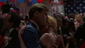 Movie still from “Something Wild” (1986), directed by Jonathan Demme – A man and a woman hugging in a crowd of people; Medium shot, Low angle