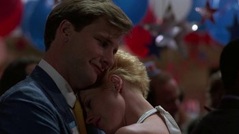 Movie still from “Something Wild” (1986), directed by Jonathan Demme – A man and a woman hugging each other in front of balloons; Close Up shot, Low angle