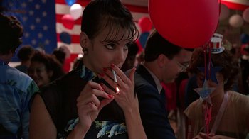 Movie still from “Something Wild” (1986), directed by Jonathan Demme – A woman smoking a cigarette in front of balloons; Close Up shot, Low angle
