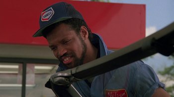 Movie still from “Something Wild” (1986), directed by Jonathan Demme – A man working on a car in a service garage; Close Up shot, Low angle