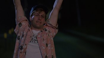 Movie still from “Something Wild” (1986), directed by Jonathan Demme – A man with his hands raised in the air; Medium shot, Low angle