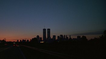 Movie still from “Something Wild” (1986), directed by Jonathan Demme – A view of a city skyline at dusk; Extreme Wide shot, Low angle