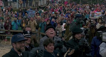 Movie still from “Groundhog Day” (1993), directed by Harold Ramis – A crowd of people standing on a street; Wide shot, High angle