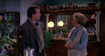 Movie still from “Groundhog Day” (1993), directed by Harold Ramis – A man and a woman are talking in a kitchen; Medium shot, Over the shoulder angle