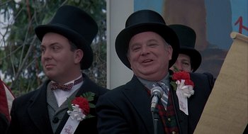 Movie still from “Groundhog Day” (1993), directed by Harold Ramis – A group of men in suits and top hats; Close Up shot, Low angle