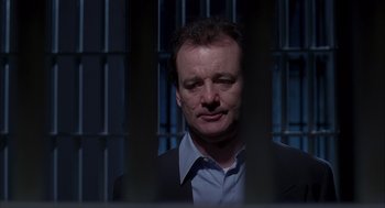 Movie still from “Groundhog Day” (1993), directed by Harold Ramis – A man in a suit standing in front of a jail cell; Close Up shot, Over the shoulder angle