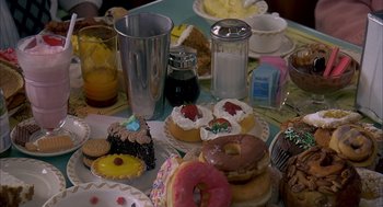 Movie still from “Groundhog Day” (1993), directed by Harold Ramis – A table full of different types of doughnuts; Extreme Close Up shot, High angle