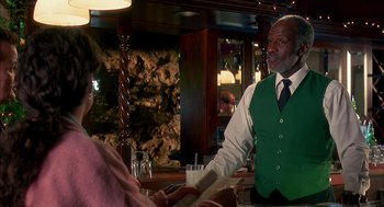 Movie still from “Groundhog Day” (1993), directed by Harold Ramis – A man standing at a bar talking to a woman; Medium shot, Over the shoulder angle