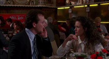 Movie still from “Groundhog Day” (1993), directed by Harold Ramis – A man and a woman sitting at a dinner table; Medium shot, Over the shoulder angle